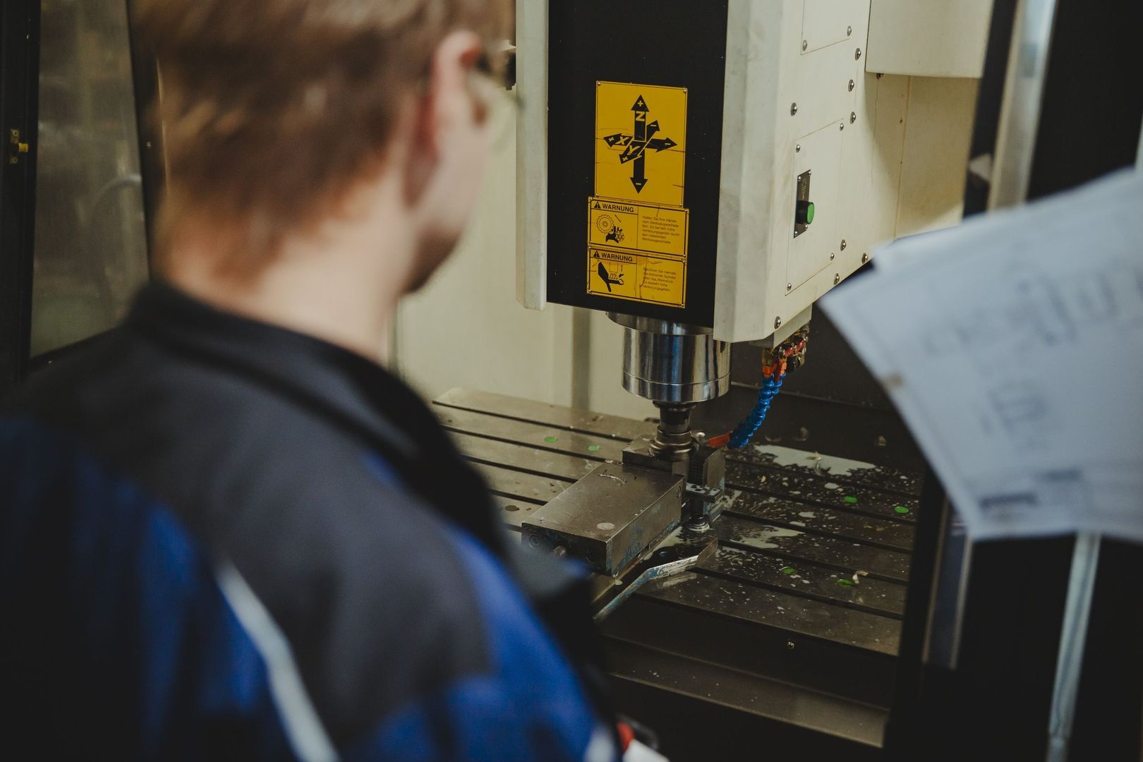 Ein Mann arbeitet an einer Maschine in einer Fabrik für Anlagenbau.